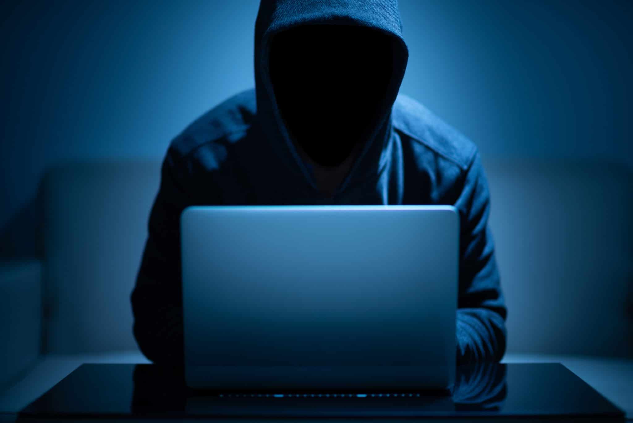 Hacker is using a laptop to commit a cybercrime in 2020.
